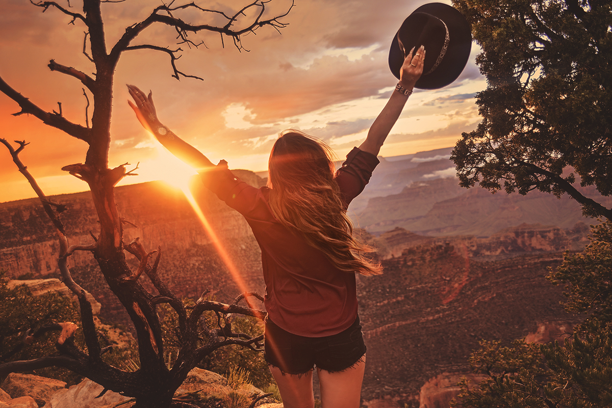 Woman with hands in the air in Grand Canyon sunset / Solnedgång i Mather Point