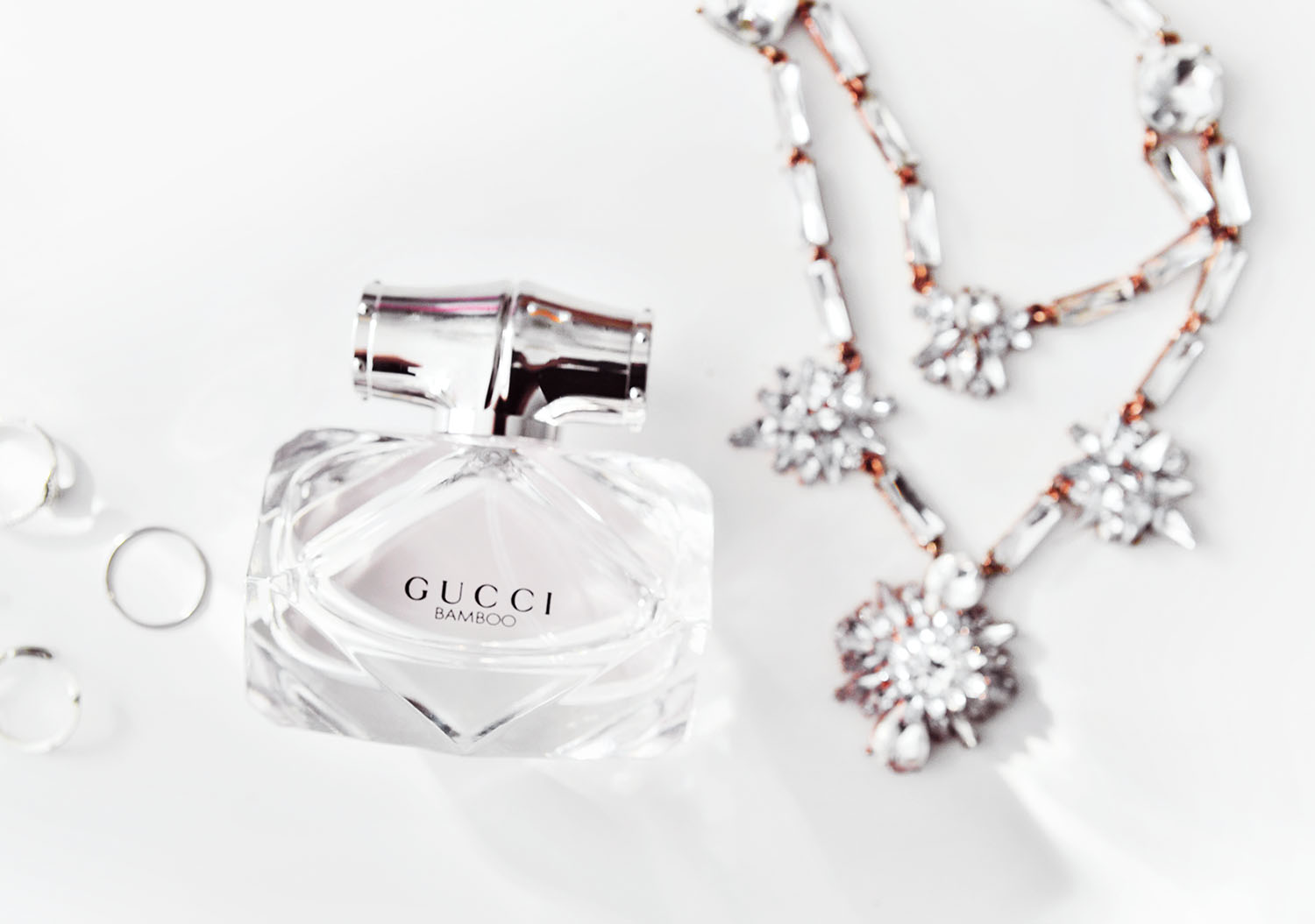 Flatlay with Gucci Bamboo Eau de Toilette & crystal necklace