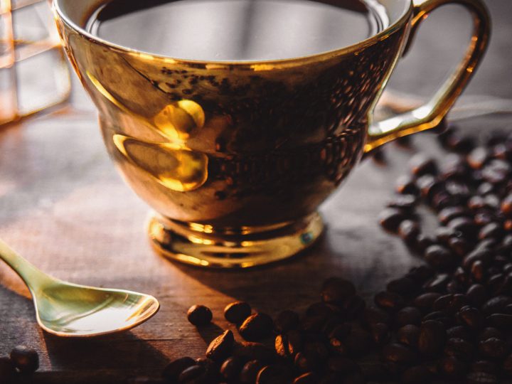 Coffe beans and a golden cup of coffee in candle light - The Nescafé Plan