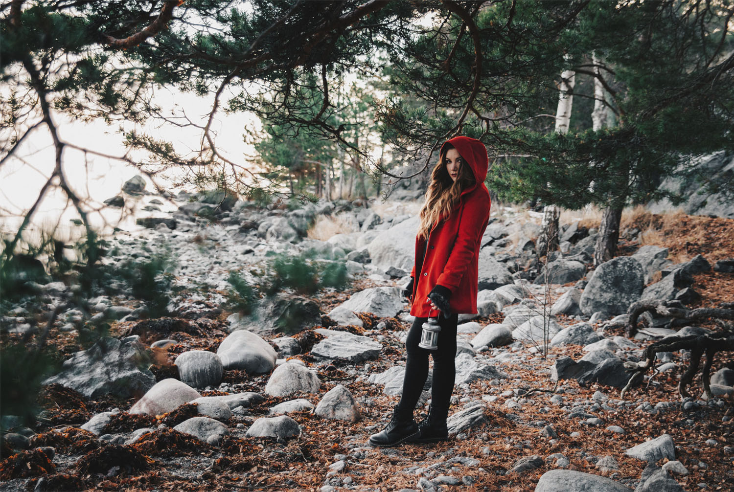 Little Red Riding Hood Fashion Story: Young woman in red cape with lantern in the woods