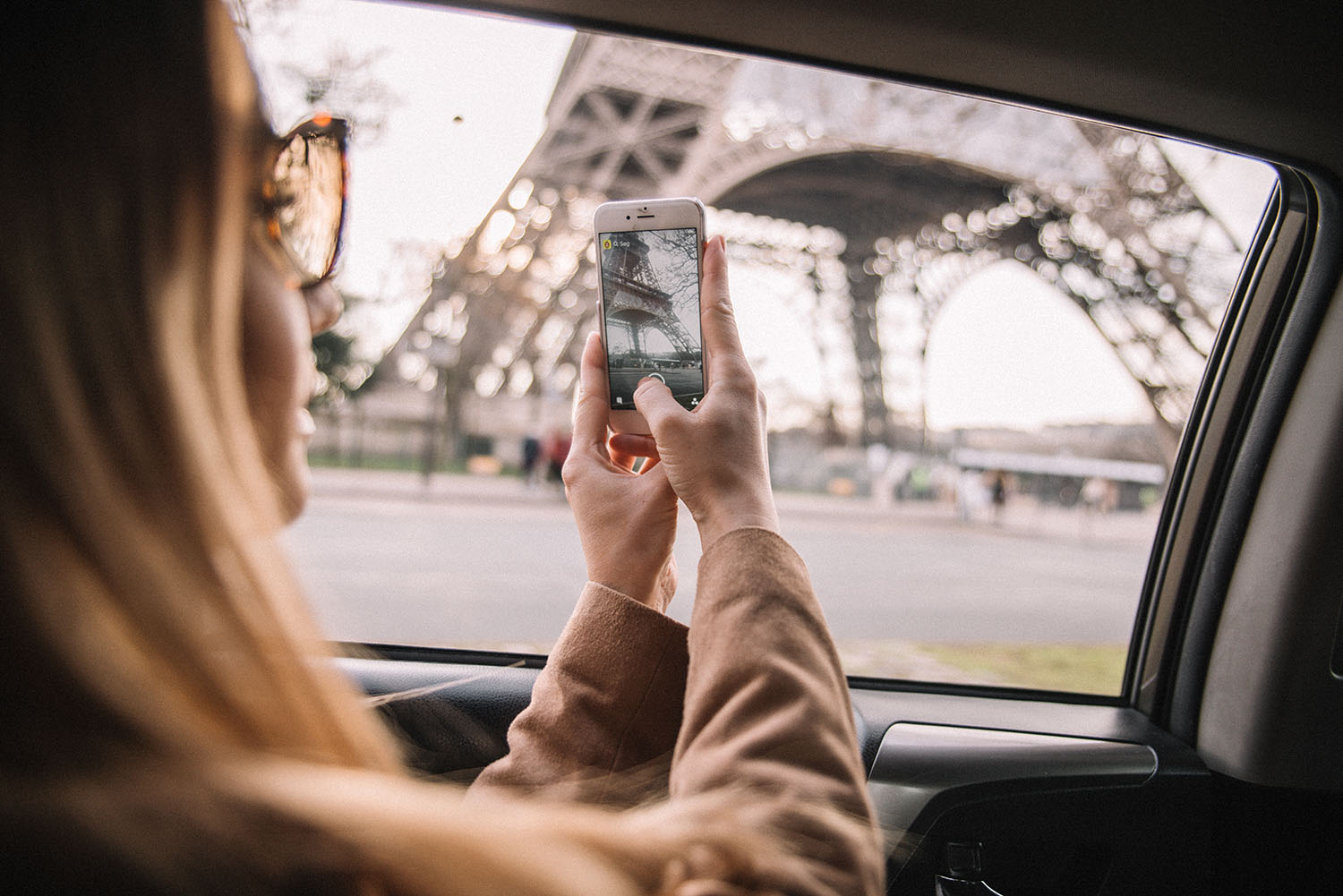 Woman with iPhone taking photo of The Eiffel Tower in Paris