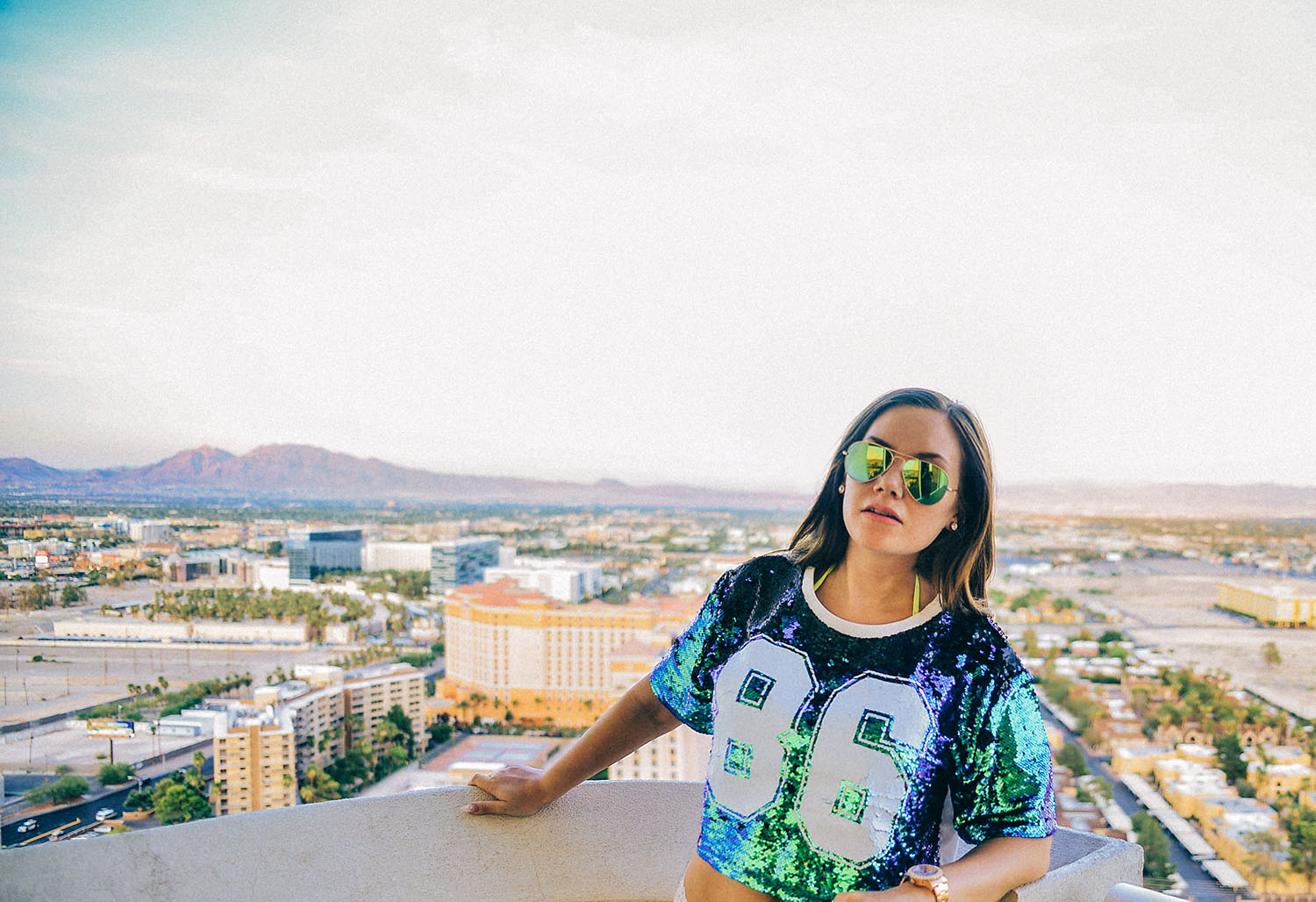 Las Vegas Baby - Woman in sequin top standing before sunset view of Vegas