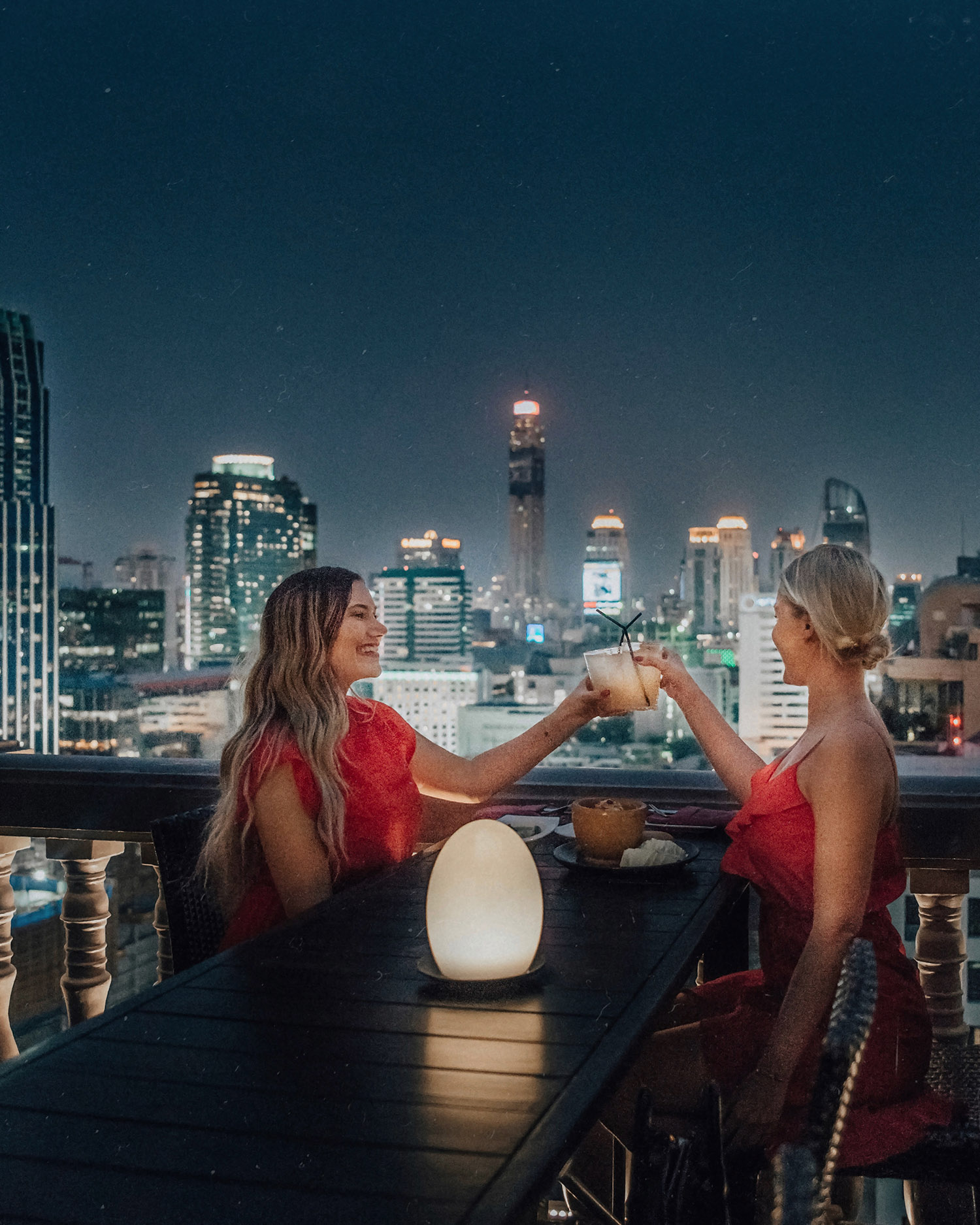 Ladies in red dresses at The Speakeasy Rooftop, Hotel Muse