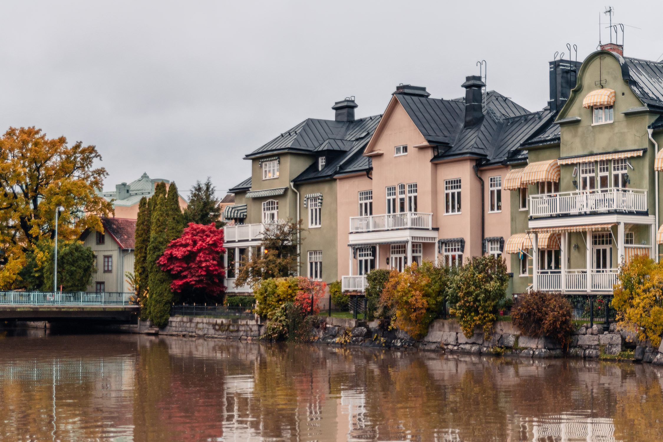 Vackra hus i grönt och rosa vid Åstråket längs Svartån i Örebro