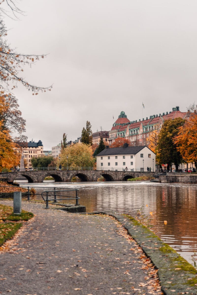 Färgglada träd och stiliga byggnader vid Svartån i stadsparken