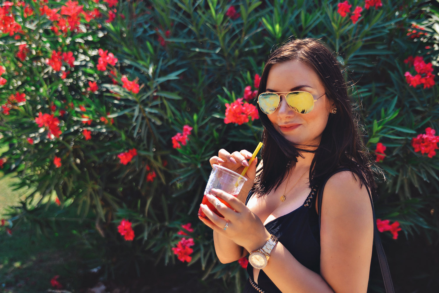 Girl wearing Gold Ray Ban Flash Lenses and drinking Strawberry Slush